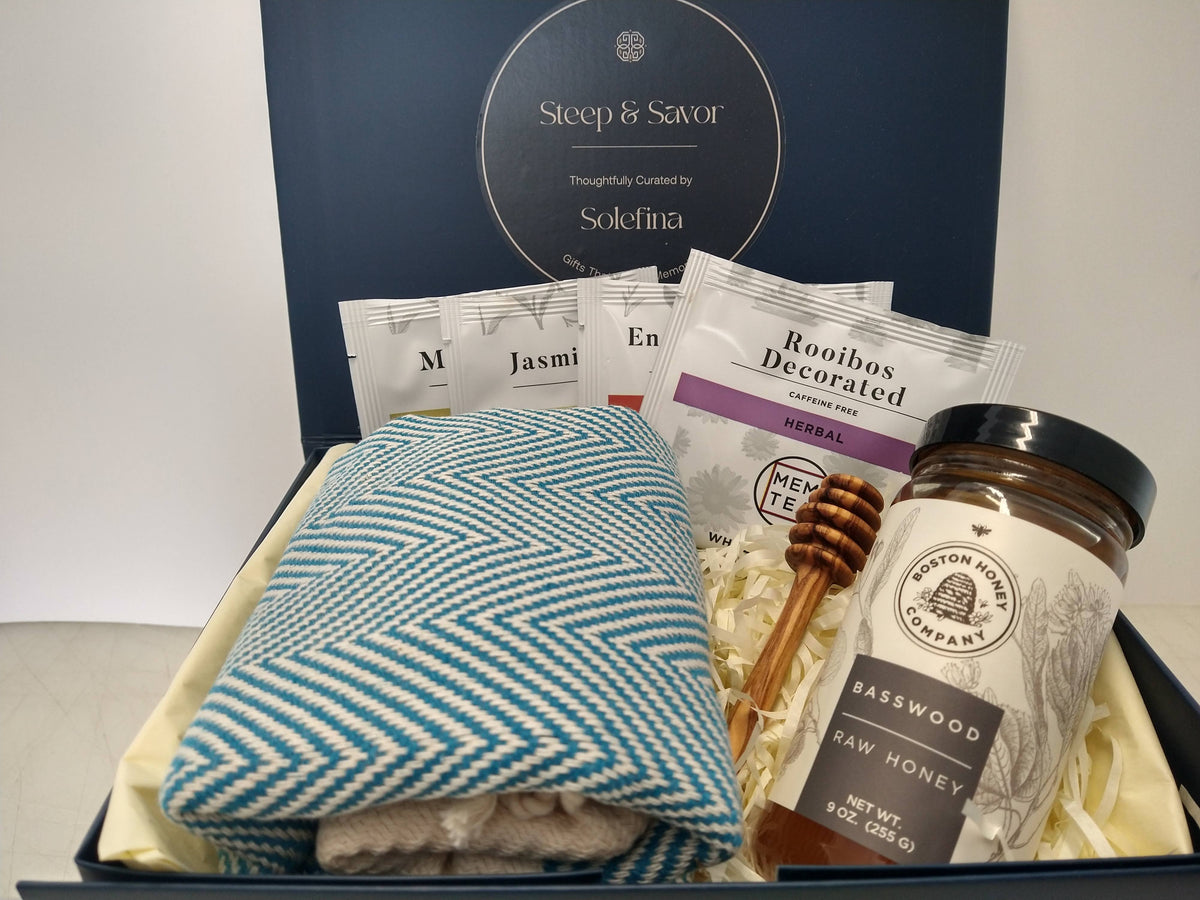 Solefina tea and honey gift box with tea sampler, basswood honey, honey dipper and blue herringbone peshtemal towel.