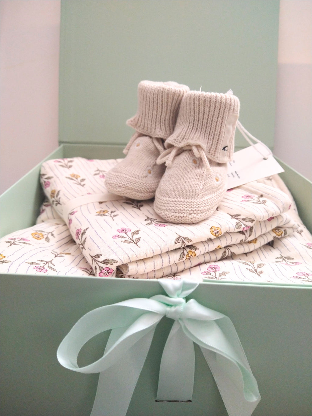 Petite Evelina Meadow Whisper baby blanket and swaddle with Saga Copenhagen Daisy booties ready to gift in Solefina gift box.