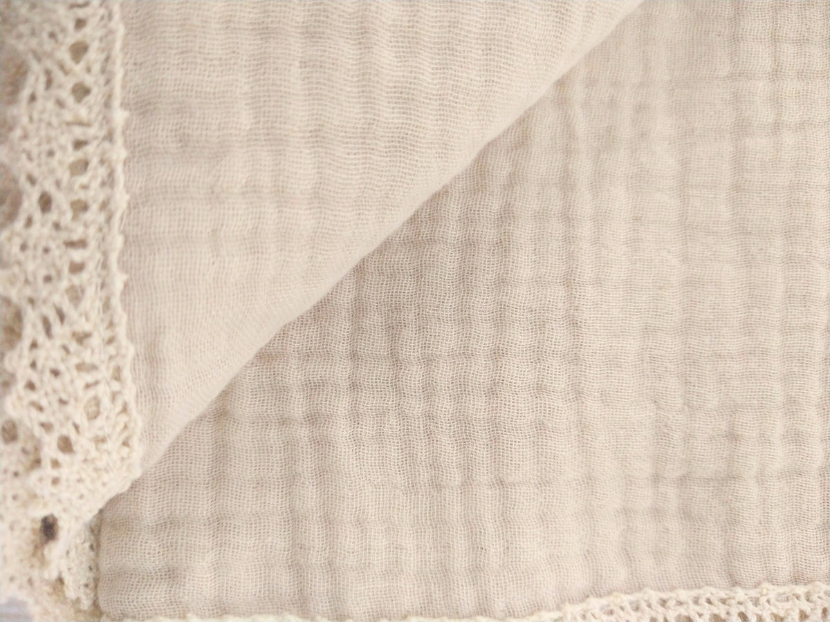 Petite Evelina light beige muslin baby swaddle showing soft layered weave and lace trim