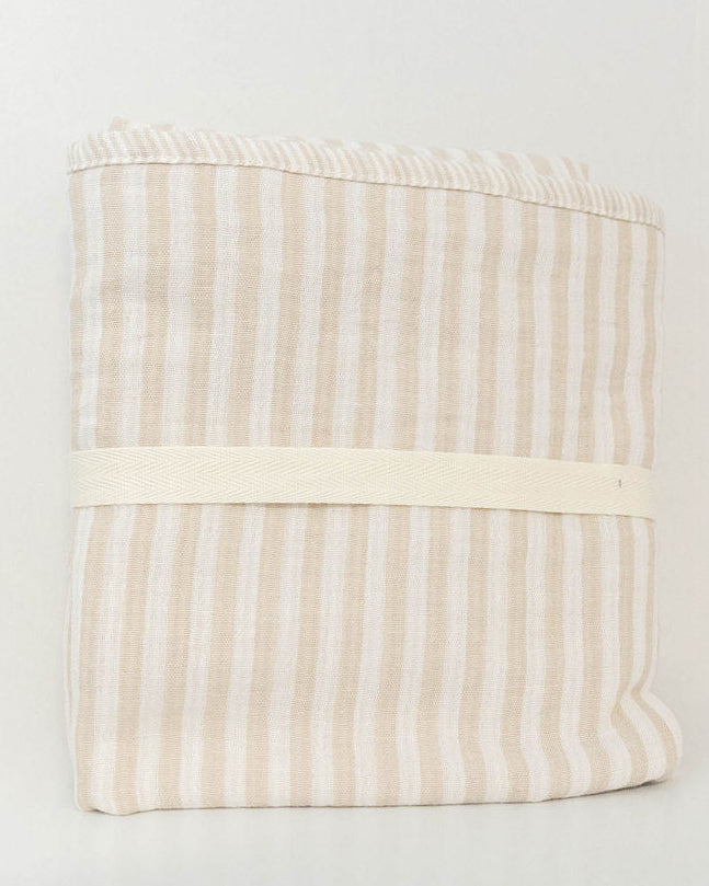 Petite Evelina beige striped muslin baby swaddle folded with a cream cotton band