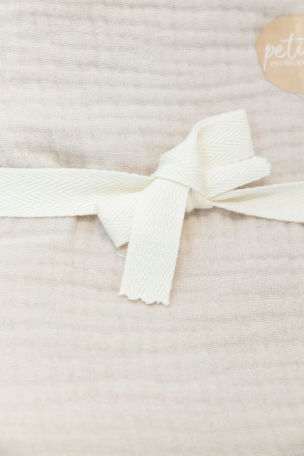 Petite Evelina light beige muslin baby swaddle showing soft layered weave 