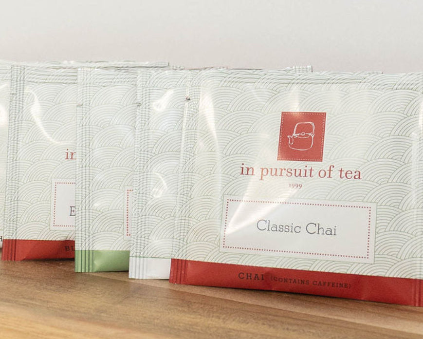 In Pursuit of Tea individually wrapped tea sachets arranged on a wooden tray