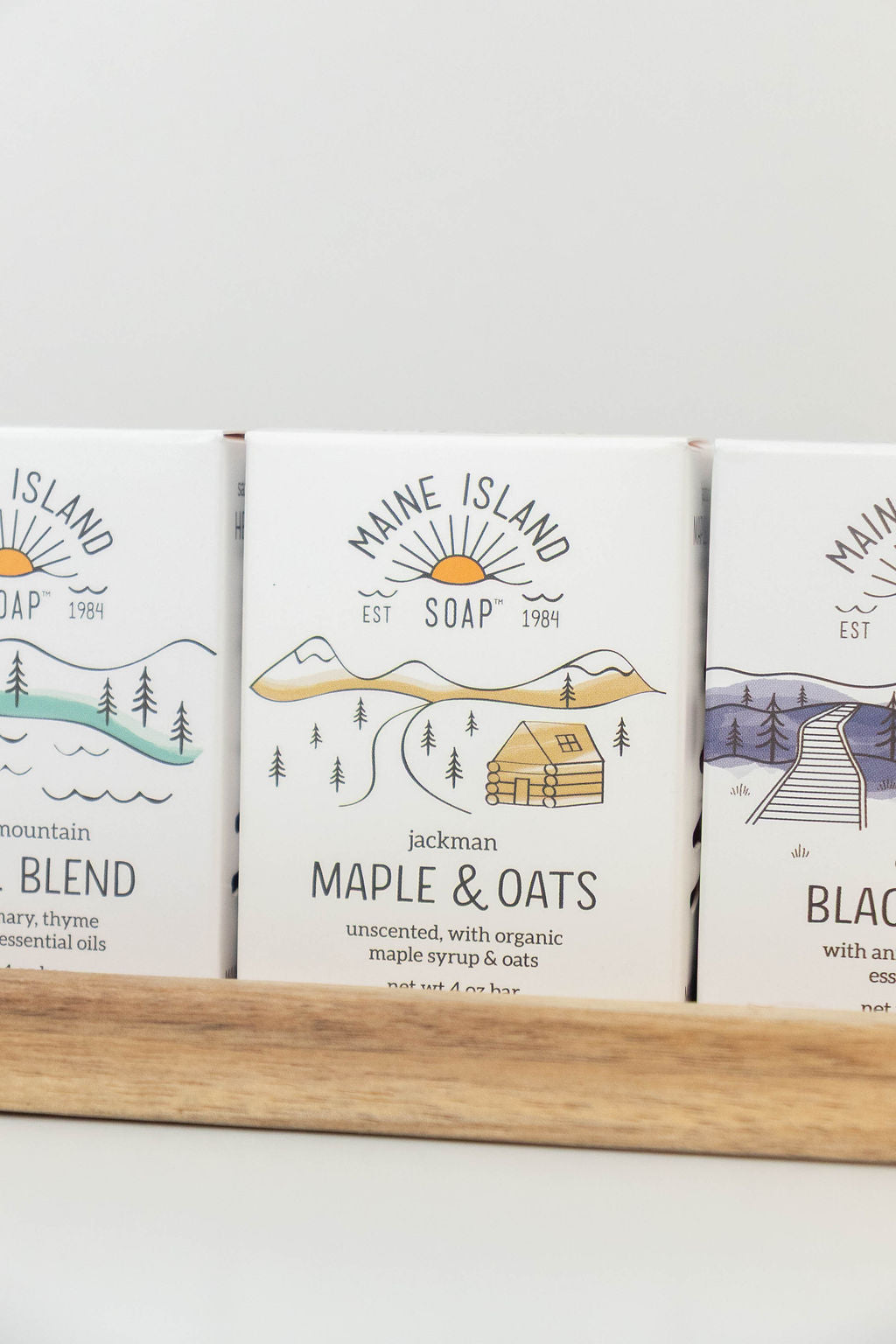Maine Island Soap Maple & Oats bar displayed with other scents on a wooden tray