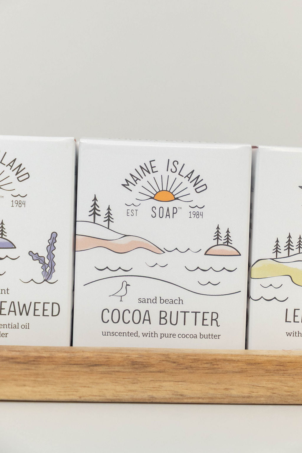 Maine Island Soap Cocoa Butter bar displayed with other scents on a wooden tray