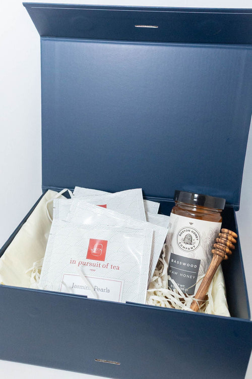 Solefina tea and honey gift box with In Pursuit of Tea sachets, basswood honey, and a wooden honey dipper.