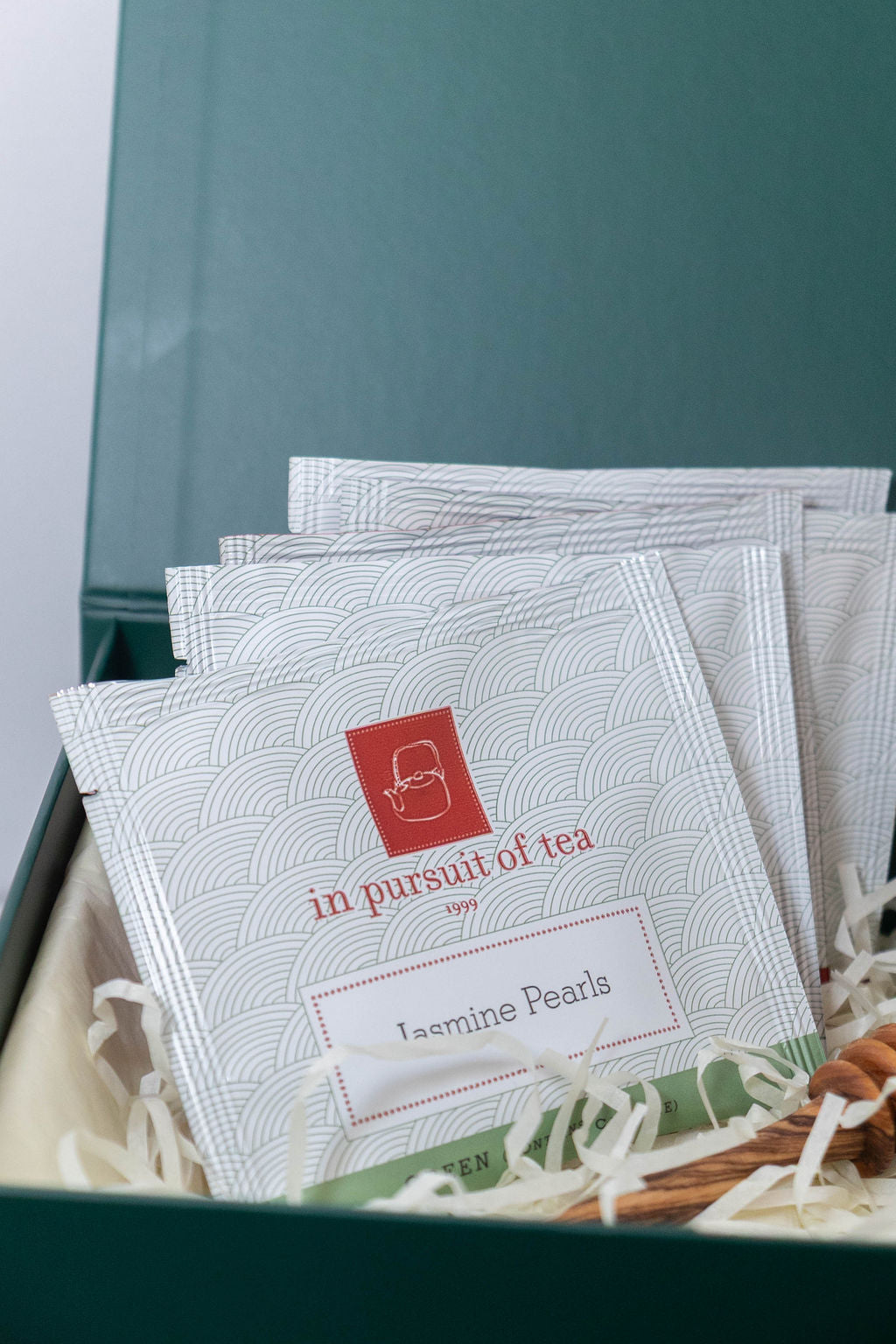 In Pursuit of Tea Jasmine Pearls tea sachets arranged in a green Solefina gift box
