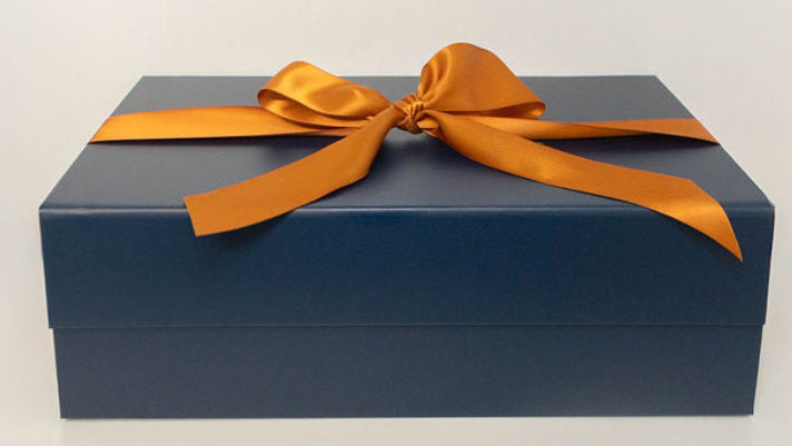 Solefina navy gift box finished with a warm copper satin ribbon.