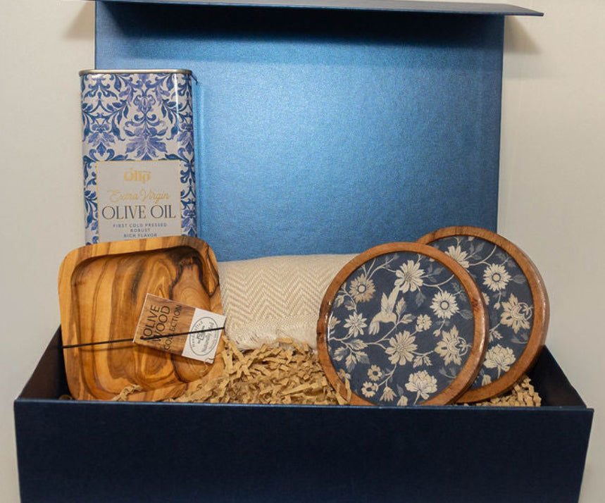 Mediterranean gift box contents with olive oil, olive wood dipping dish, floral coasters and peshtemal towel.