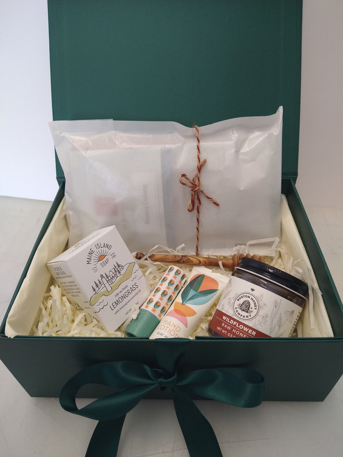 Student care package in a green gift box with tea, wildflower honey, honey dipper, lemongrass soap, hand lotion and lip balm.