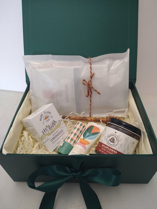 Student care package in a green gift box with tea, wildflower honey, honey dipper, lemongrass soap, hand lotion and lip balm.