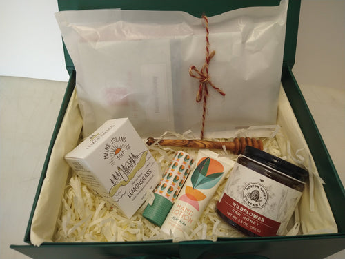 Student care package in a green gift box with tea, wildflower honey, honey dipper, lemongrass soap, hand lotion and lip balm.