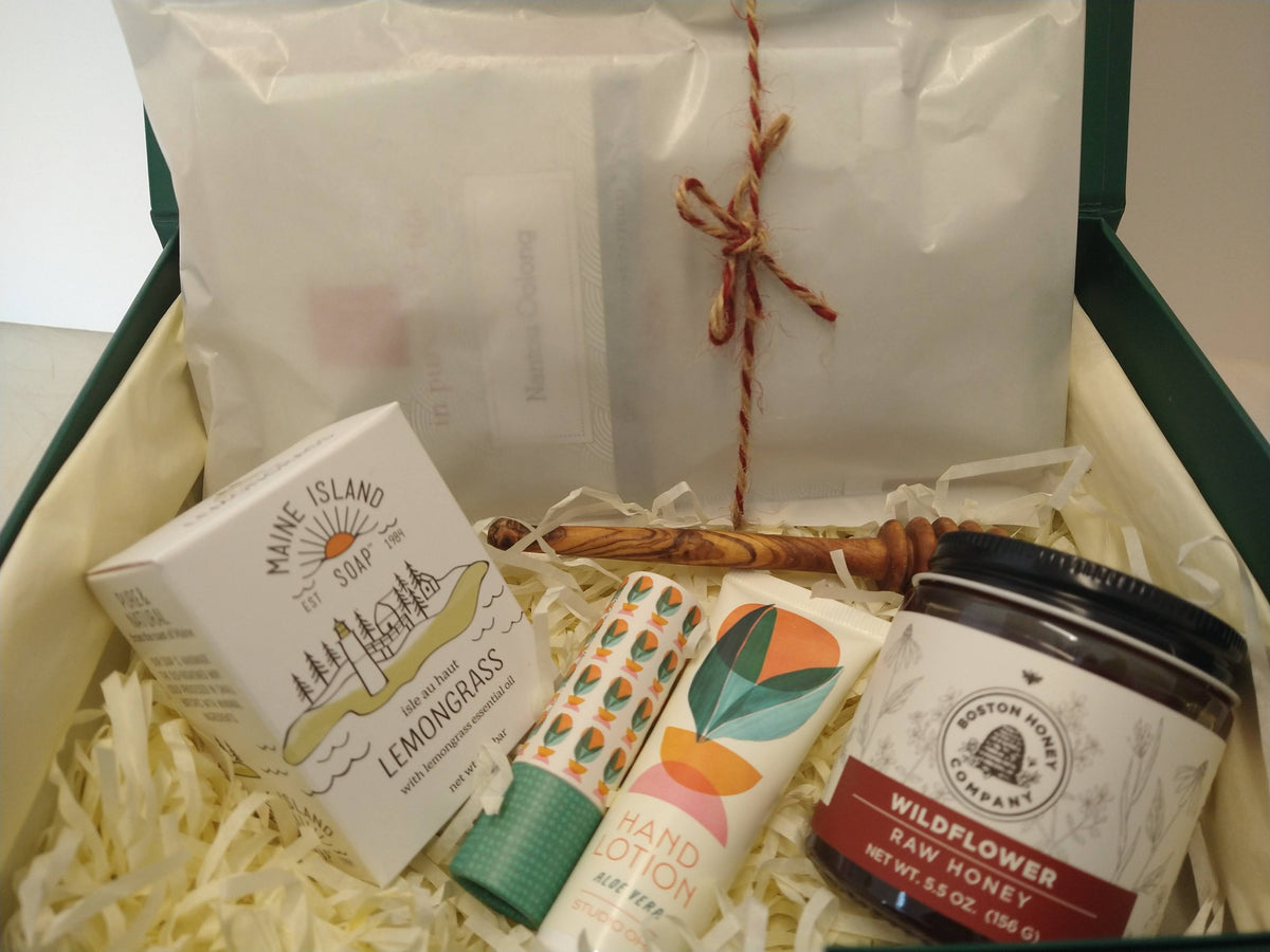Student care package in a green gift box with tea, wildflower honey, honey dipper, lemongrass soap, hand lotion and lip balm.
