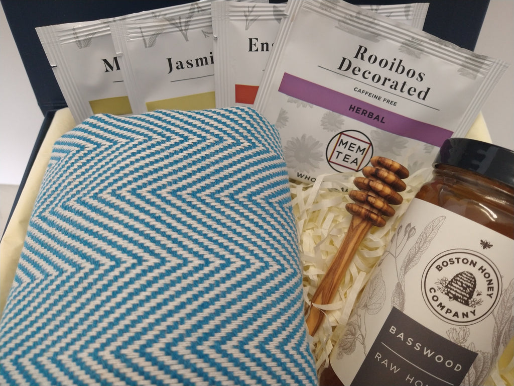 Solefina tea and honey gift box with tea sampler, basswood honey, honey dipper and blue herringbone peshtemal towel.