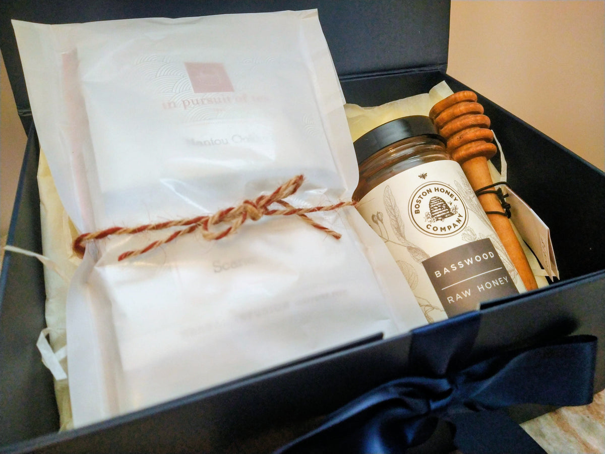 Solefina tea and honey gift box with In Pursuit of Tea sachets, basswood honey, and a wooden honey dipper.