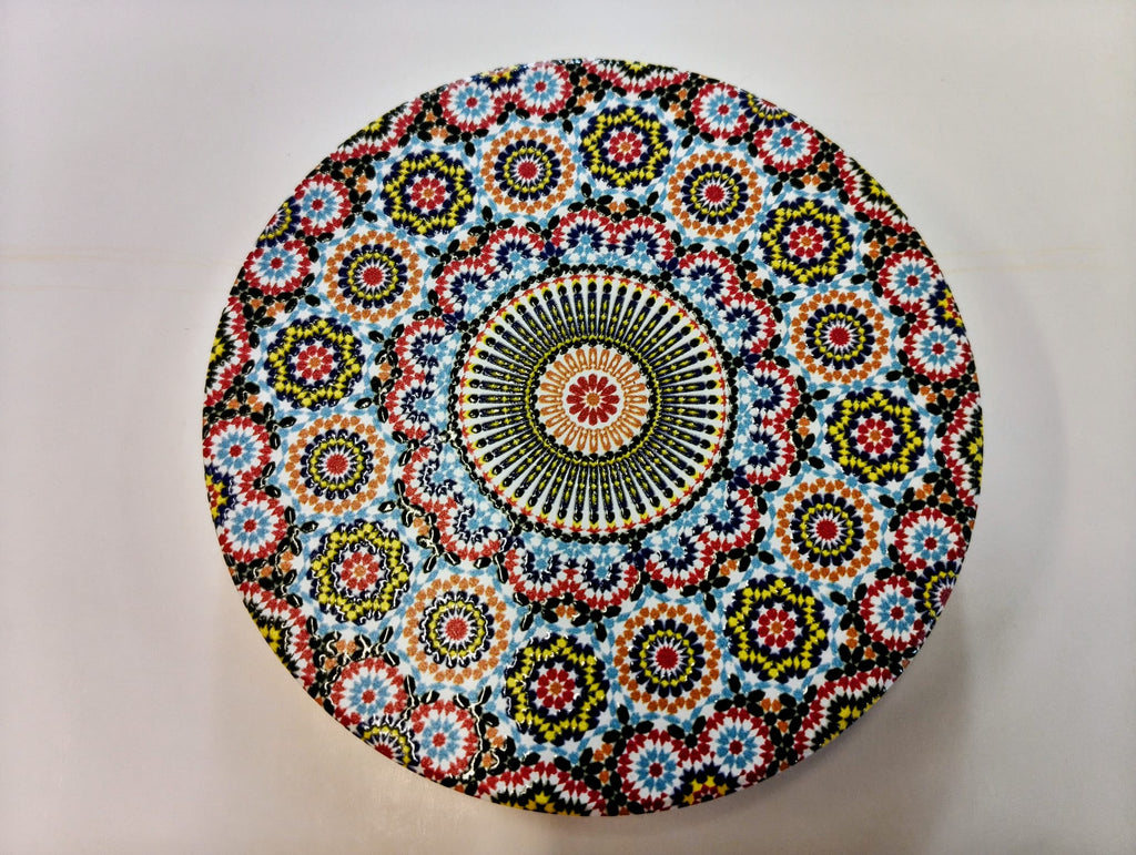 Round Moroccan-inspired ceramic coaster featuring densely arranged floral and geometric mosaic patterns in turquoise, blue, orange, red, yellow and white, surrounding a detailed circular medallion.
