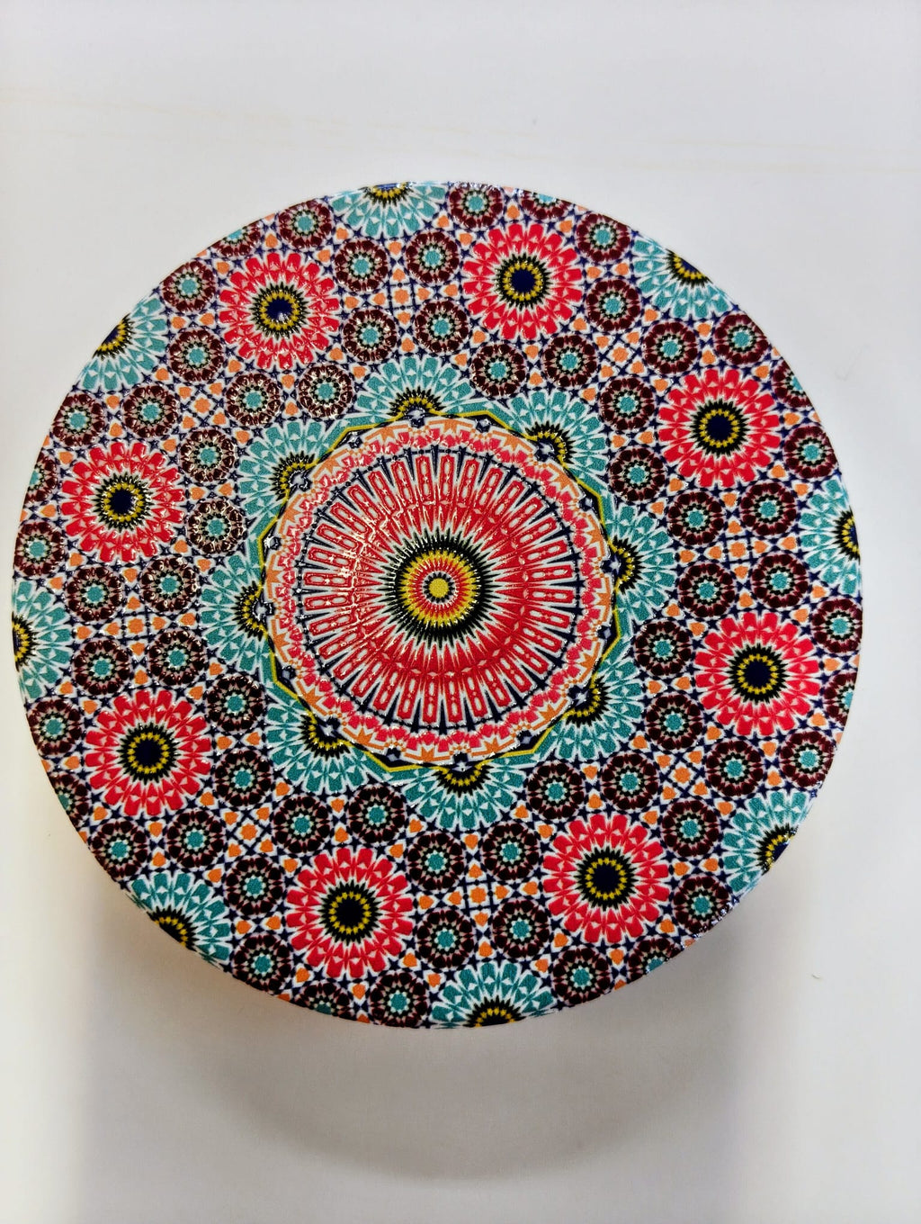 Round Moroccan-inspired ceramic coaster featuring intricate concentric floral and geometric mosaic patterns in pink, turquoise, red, blue, green and white.
