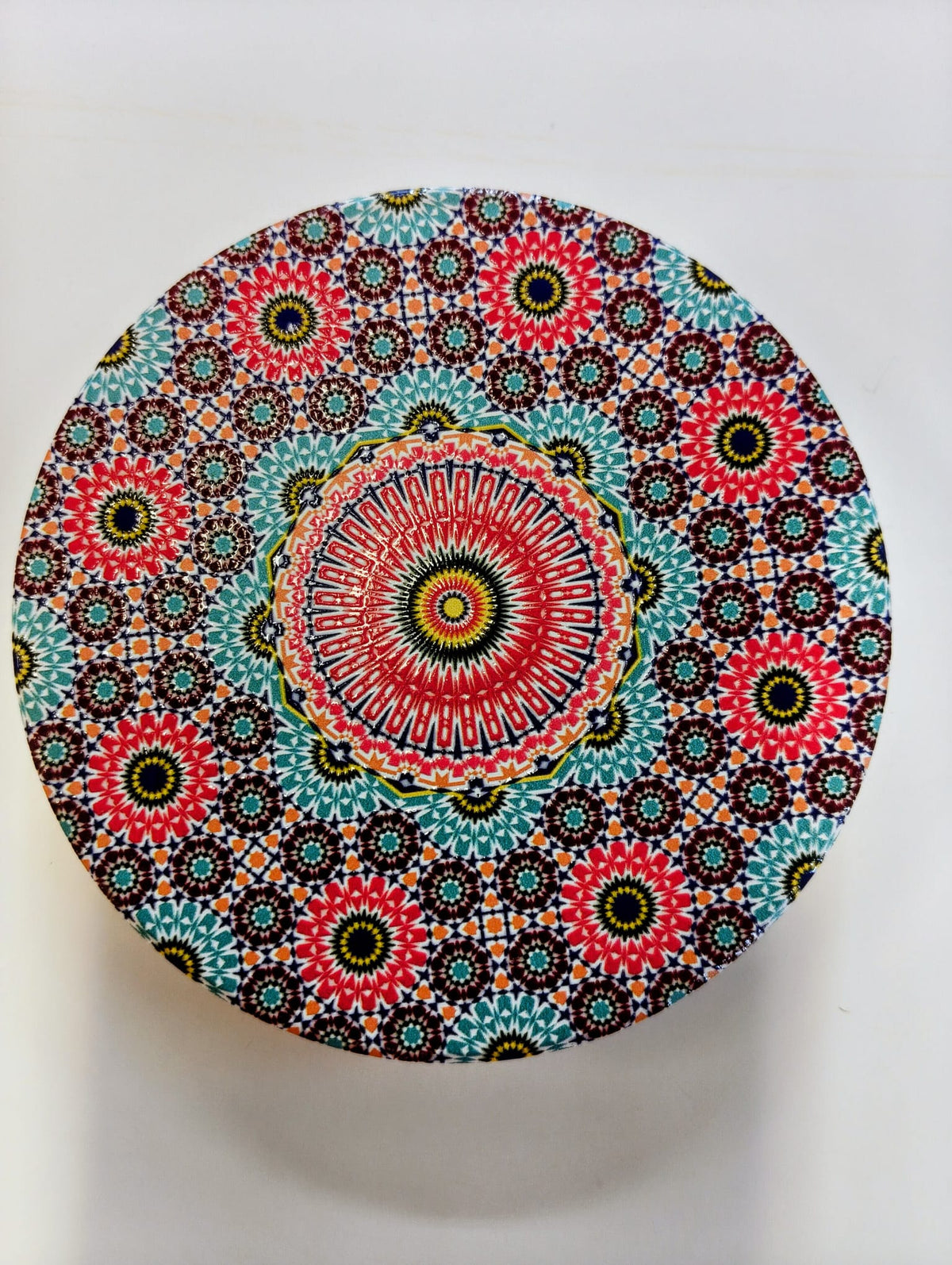 Round Moroccan-inspired ceramic coaster featuring intricate concentric floral and geometric mosaic patterns in pink, turquoise, red, blue, green and white.
