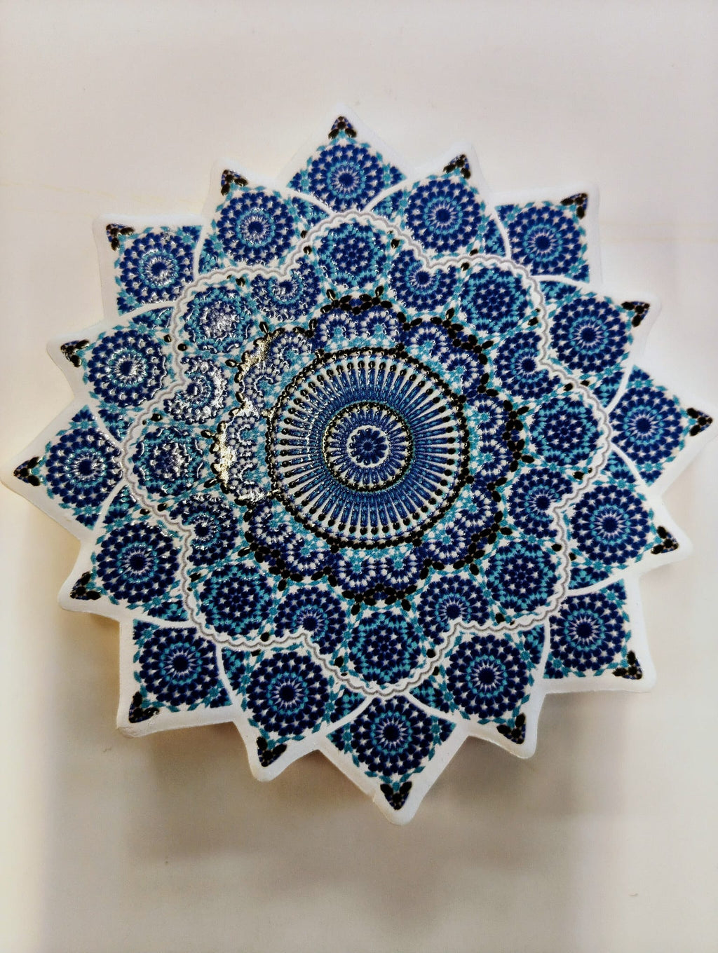 Star-shaped Moroccan-inspired ceramic coaster featuring intricate concentric floral and geometric mosaic patterns in cobalt blue, navy and white, with pointed edges.