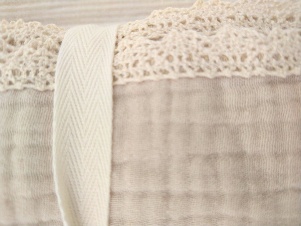 Petite Evelina light beige muslin baby swaddle showing delicate lace trim